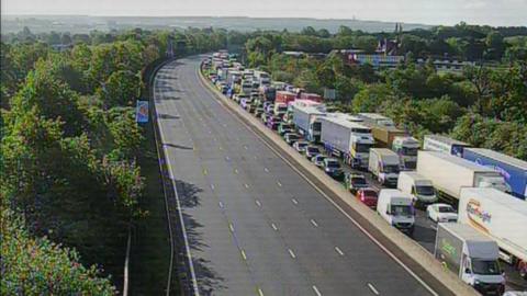 An overhead view of a motorway, where one side is heavily congested with traffic.