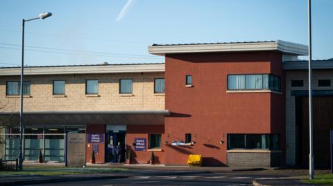The image shows a general view of HMP Bronzefield in Ashford, Surrey.