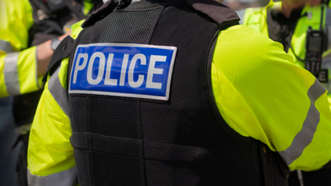 The back of a police officer stood next to two others 