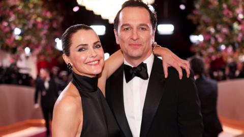 Keri Russell and Matthew Rhys hugging and smiling at the camera