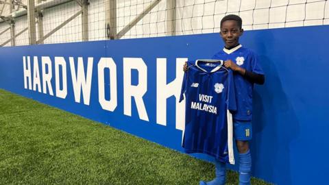 Calvin stands with T-shirt at Cardiff City