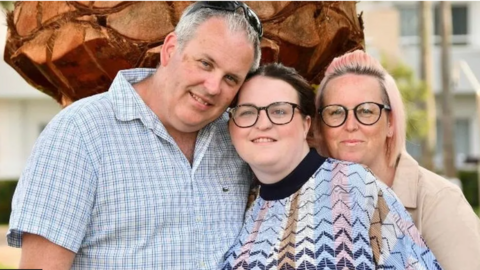 A man and two women smiling towards the camera