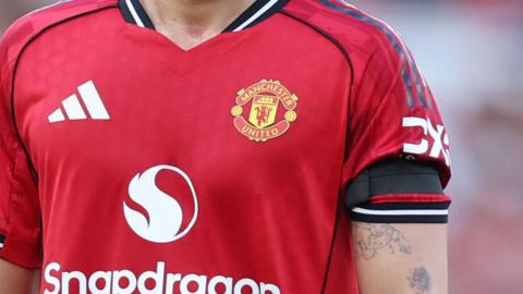 A Manchester United player wearing a black armband