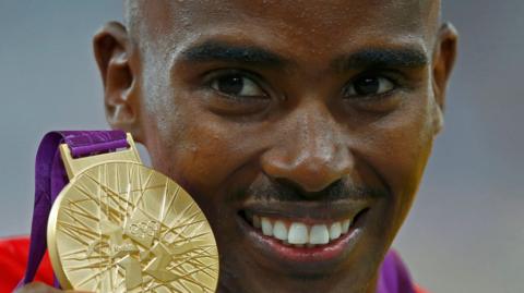 Britain's Mo Farah holds his gold medal for the men's 5000m at the victory ceremony at the London 2012 Olympic Games.