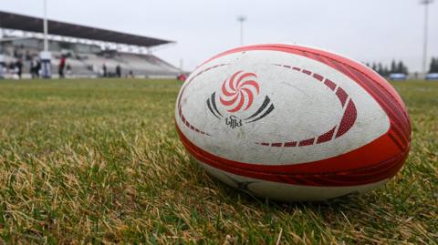A Georgia rugby ball sits on a pitch