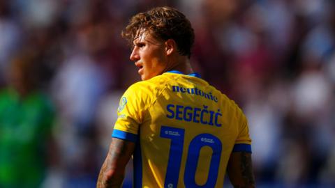 A close-up of Adrian Segecic in his yellow Portsmouth kit during their game against West Ham in the first round of the EFL Cup