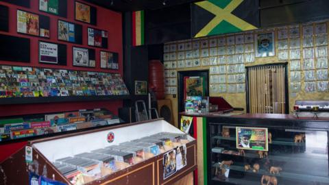 Interior of music shop People's Sound Records shows Jamaican flag, records, CDs and posters