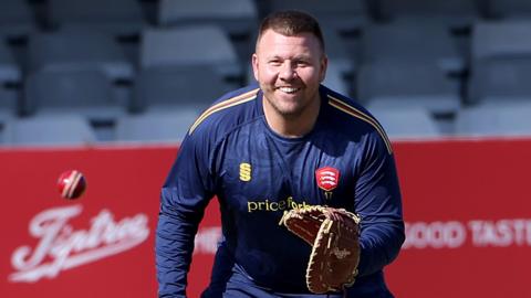 Adam Rossington wearing a catcher mitt during fielding practice