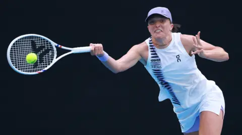 Iga Swiatek returns a serve