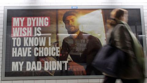 Pedestrians walk past the posters promoting the Assisted Dying bill at Westminster Underground station in London, Britain, on 27 November 2024