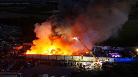 Aerial view of Red Lodge on fire with crews damping down