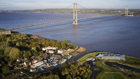 An aerial picture of the Humber Bridge. The shot shows part of Barton-upon-Humber and a large green space by the side of the water.