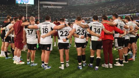 Wales players in a huddle after 43-0 defeat to South Africa