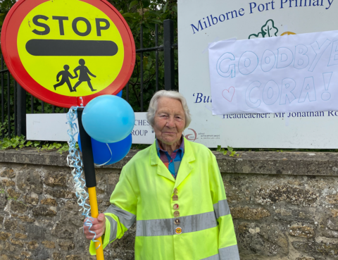 Women holding lollipop stood in high-viz jacket