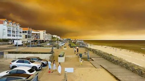 Beach goers walk next to the beach in Lacanau Ocean, southwestern France on July 24, 2026, as clouds of smoke rise into the sky from a wildfire.
