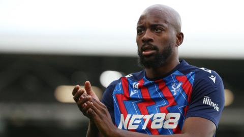 Jean-Philippe Mateta applauds the Crystal Palace fans during his warm-up