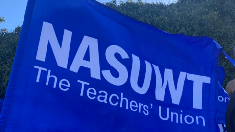 A blue flag with 'NASUWT The Teachers' Union' written in white text. 