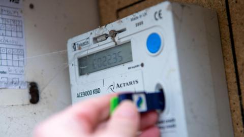 A customer checks the credit on a prepayment electricity meter. 