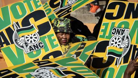 A woman surrounded by ANC placards