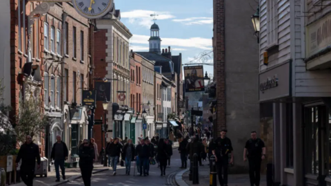 An image of pedestrians walking down Rochester High Street in Medway, Kent.