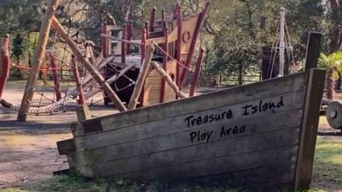 A wooden boat feature with a play area inside it.