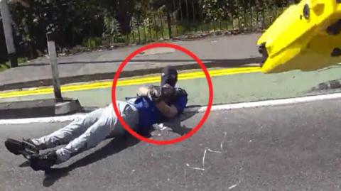 Man in balaclava points weapon at camera