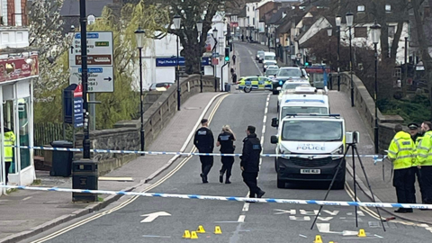 Police officers vehicles and uniformed officers at the scene