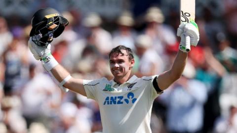 New Zealand captain Tom Latham raises his helmet and bat after hitting a century