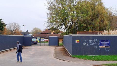 dark blue tall wooden hoardings surrounding a building that is the old three counties hotel.