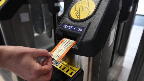 Card train ticket being entered into a ticket barrier machine