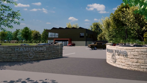 An artist's impression of the new gym at the former Chris Jewkes Leisure Centre in Tettenhall with brick walls at either side of the entranceway with the words Hamiltons on them and a large brown building in the background, on the other side of a car park