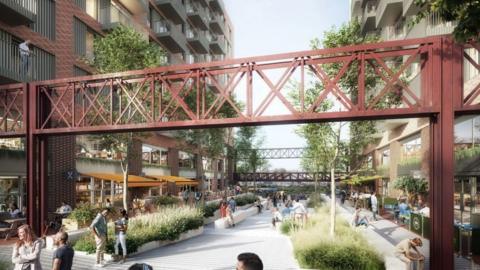 A computer generated image of how the development on Silverthorne Lane could look. It is an industrial style complex with corrugated metal walls and red metal bridges suspended above a large courtyard area, which has plant beds and benches. There are lots of people socialising in the courtyard, where there are restaurants and bars.
