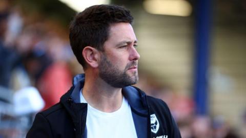 Oxford United manager Des Buckingham watches a game from the touchline