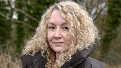 Dr Samantha Jenkins who has curly blonde hair 