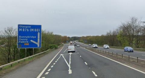 A motorway with a number of vehicles travelling on it. On the left hand side of the motorway is a sign for Glasgow, Bonnybridge, Denny and Falkirk