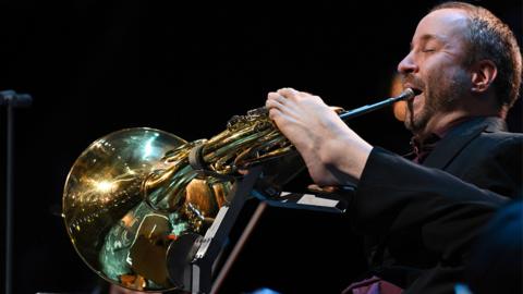 Man playing the French horn with his foot