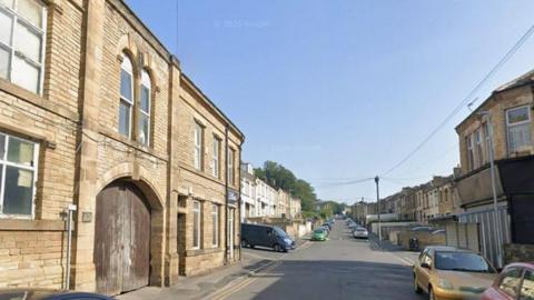 A residential street with an industrial building.