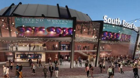 A CGI image of what the new arena could look like. It is a bowl-shaped building that is made of brown bricks and has a grey roof. Festoon lights are hanging off various parts of the building, which has a crowd of people milling about outside it. There is a neon sign that says "South Essex Arena" above one entrance.