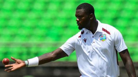 West Indies bowler Jayden Seales grabs a ball before bowling