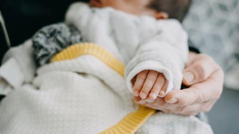 close up of a baby being held in someone's arms 