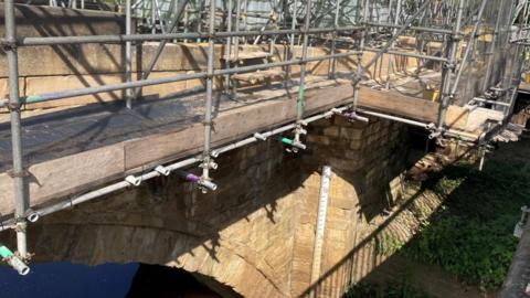 Scaffolding over a stone bridge