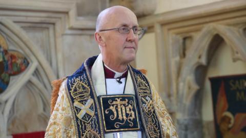 Bishop of Bath and Wells Michael Beasley photographed wearing his religious attire in a cathedral.