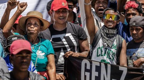 Residents and protesters cheer and hold banners as they gather for a civil society rally outside City Hall in Antananarivo, on Monday.