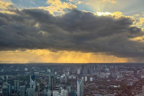 London skyline with blue skies at height but also large looming shower clouds
