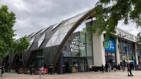 The entrance to the Moor Market in Sheffield, a dome-style building with glass exterior.