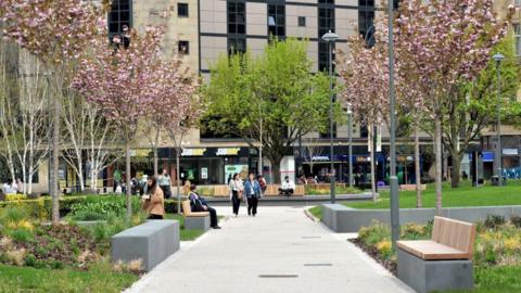 Norfolk Gardens in Bradford city centre, a pedestrianised green space with walkways and benches.