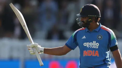 India opener Rohit Sharma raises his bat after hitting a century
