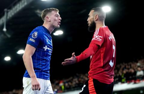 Liam Delap of Ipswich Town squares up to Manchester United's Noussair Mazraoui during the Premier League match at Portman Road