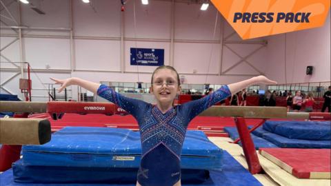 Young gymnast Millie holding her arms up