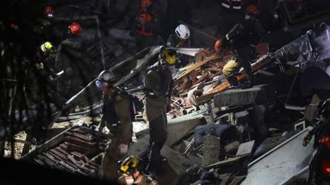  Israeli search and rescue personnel work on the site of a residential building that was destroyed by an Iranian strike in the neighbourhood in Haifa on April 5, 2026. Israeli firefighters were searching for three missing people in the rubble of a residential building in the northern city of Haifa after it was struck by an Iranian missile April 5. 